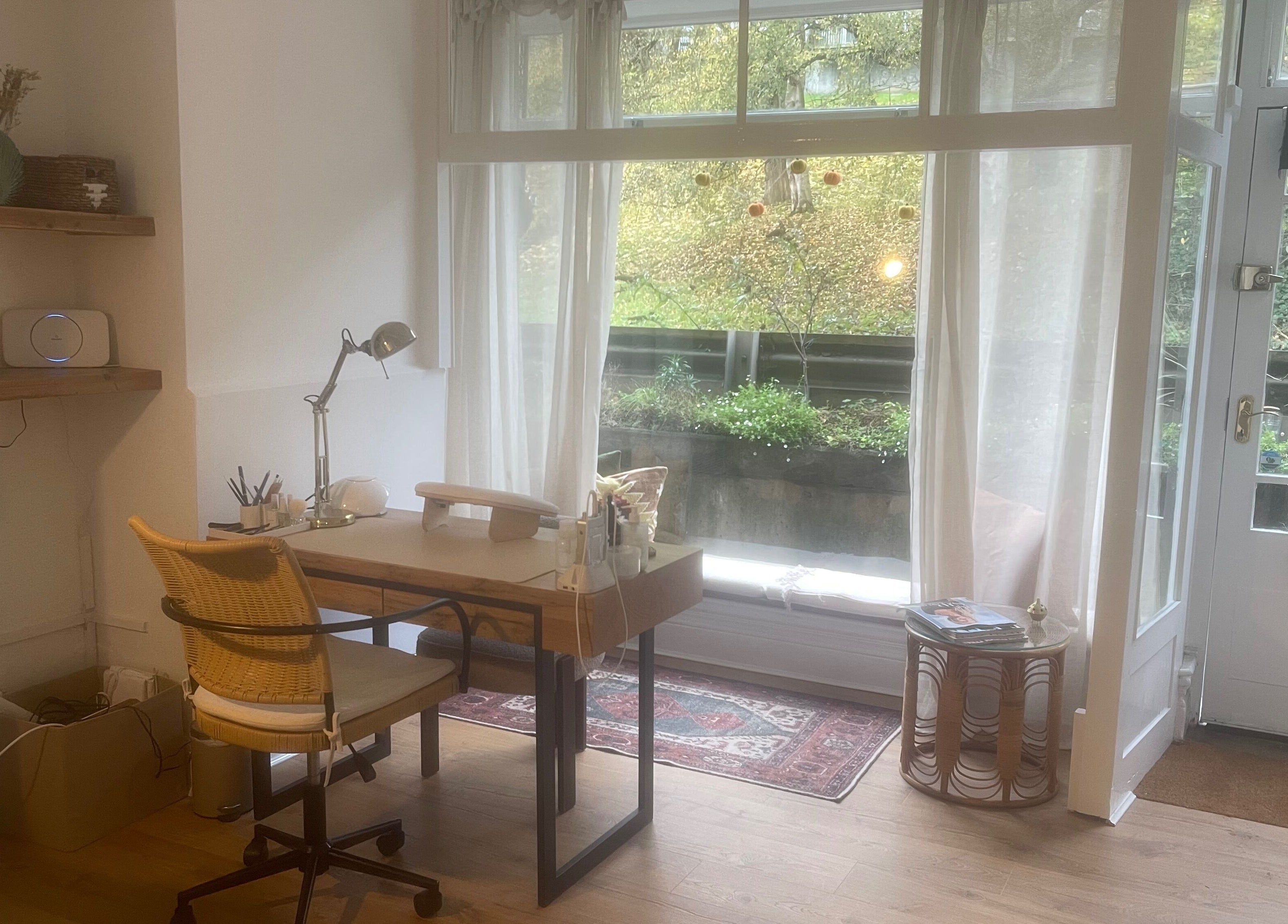 Cozy workspace at Skin by Fran, Bath, England, GB with wooden desk, chair, and large window view.