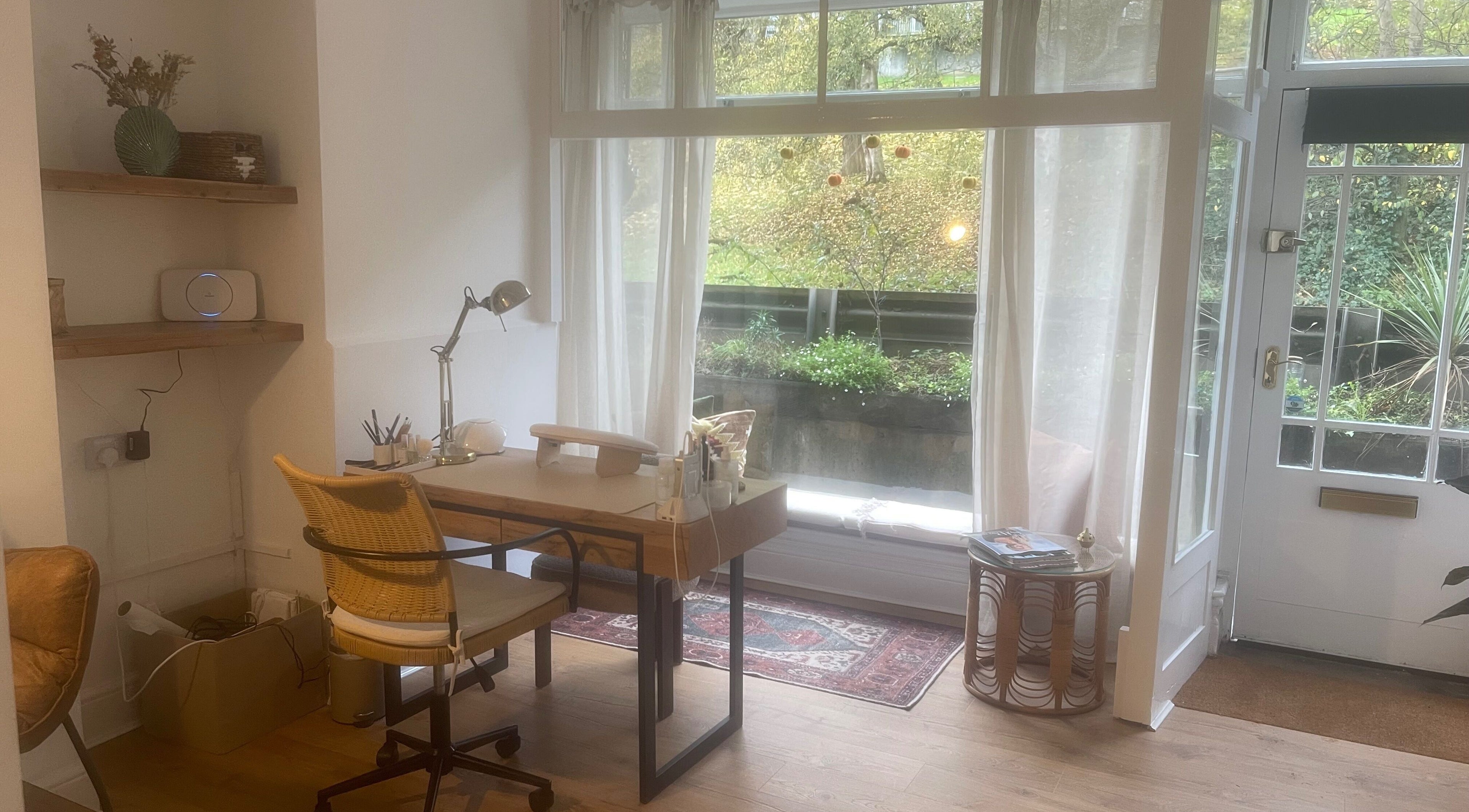 Cozy workspace at Skin by Fran, Bath, England, GB with wooden desk, chair, and large window view.
