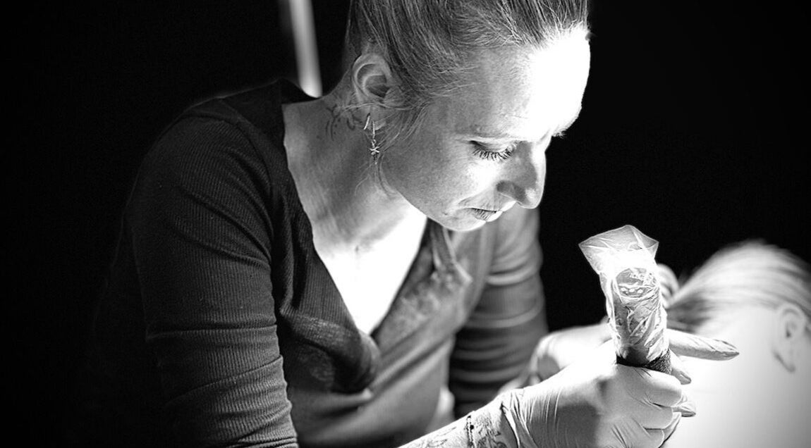 Artiste tatoueur à Alaïz Arts en action à Bourg-l'évêque, Pays De La Loire, FR, créant un art corporel unique.