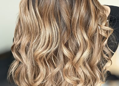 Cheveux ondulés et brillants chez Beautynco à Champs-sur-Marne, Île-de-France, FR, mettant en valeur des mèches dorées.