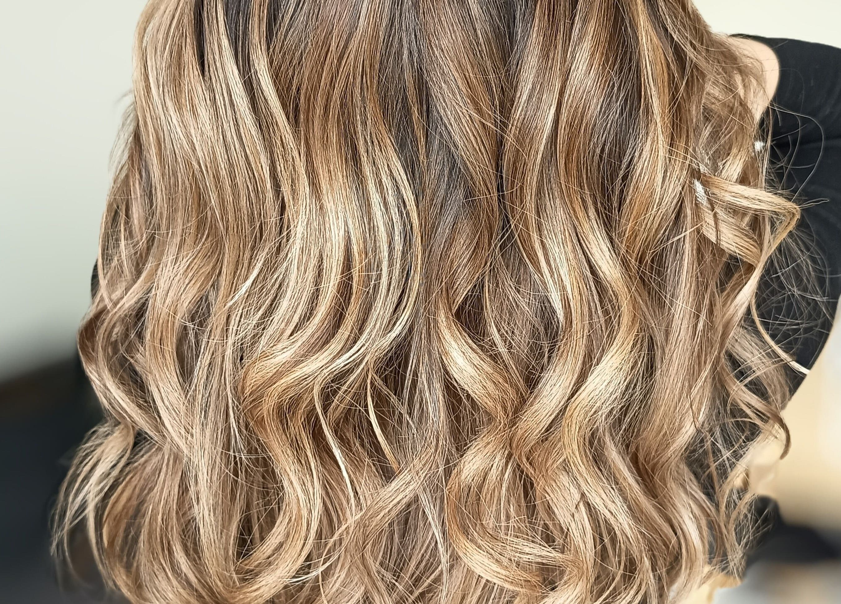 Cheveux ondulés et brillants chez Beautynco à Champs-sur-Marne, Île-de-France, FR, mettant en valeur des mèches dorées.