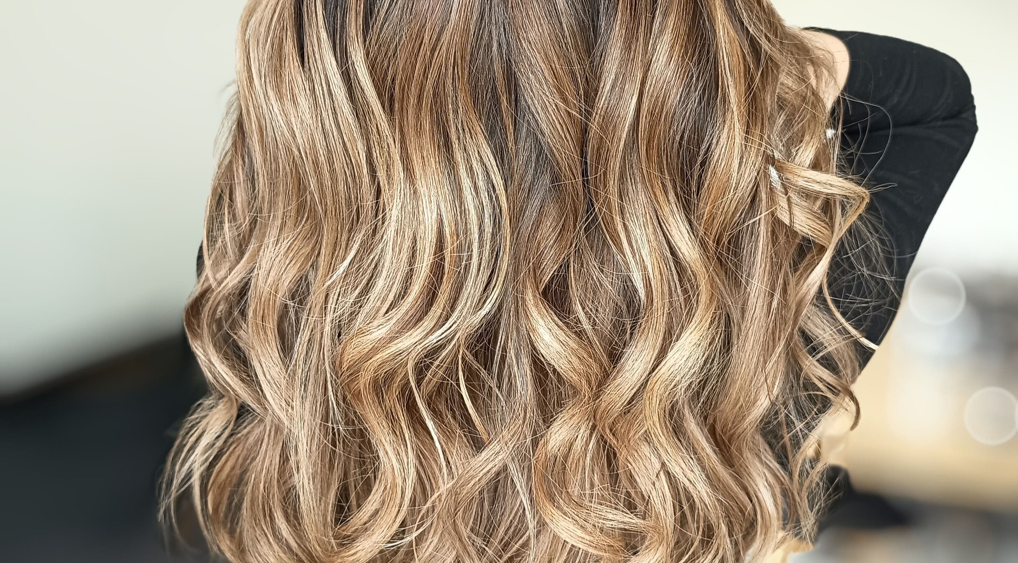 Cheveux ondulés et brillants chez Beautynco à Champs-sur-Marne, Île-de-France, FR, mettant en valeur des mèches dorées.