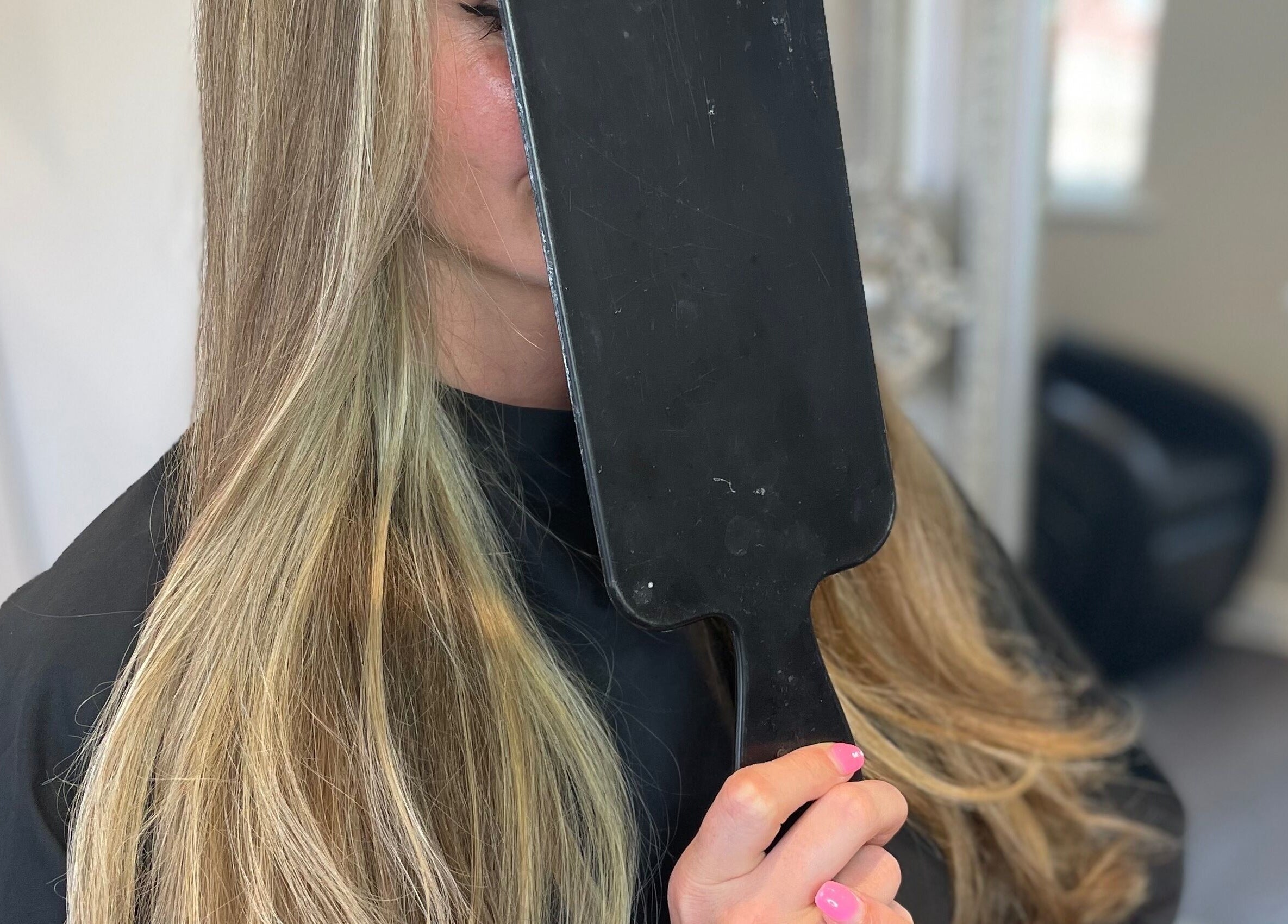 A client admires her silky hair in a mirror at Meraki Hairdressing, Runcorn, England, GB.