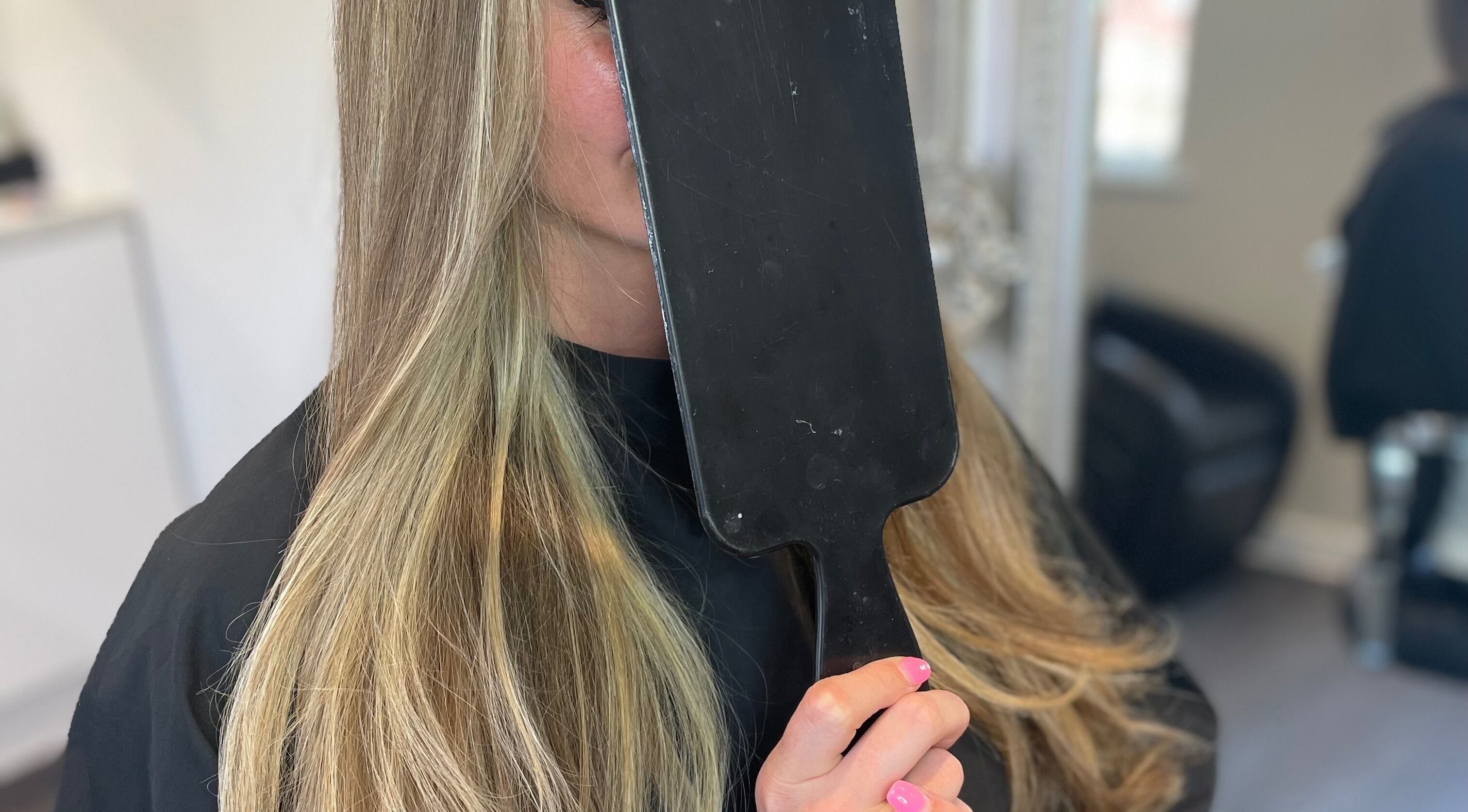A client admires her silky hair in a mirror at Meraki Hairdressing, Runcorn, England, GB.