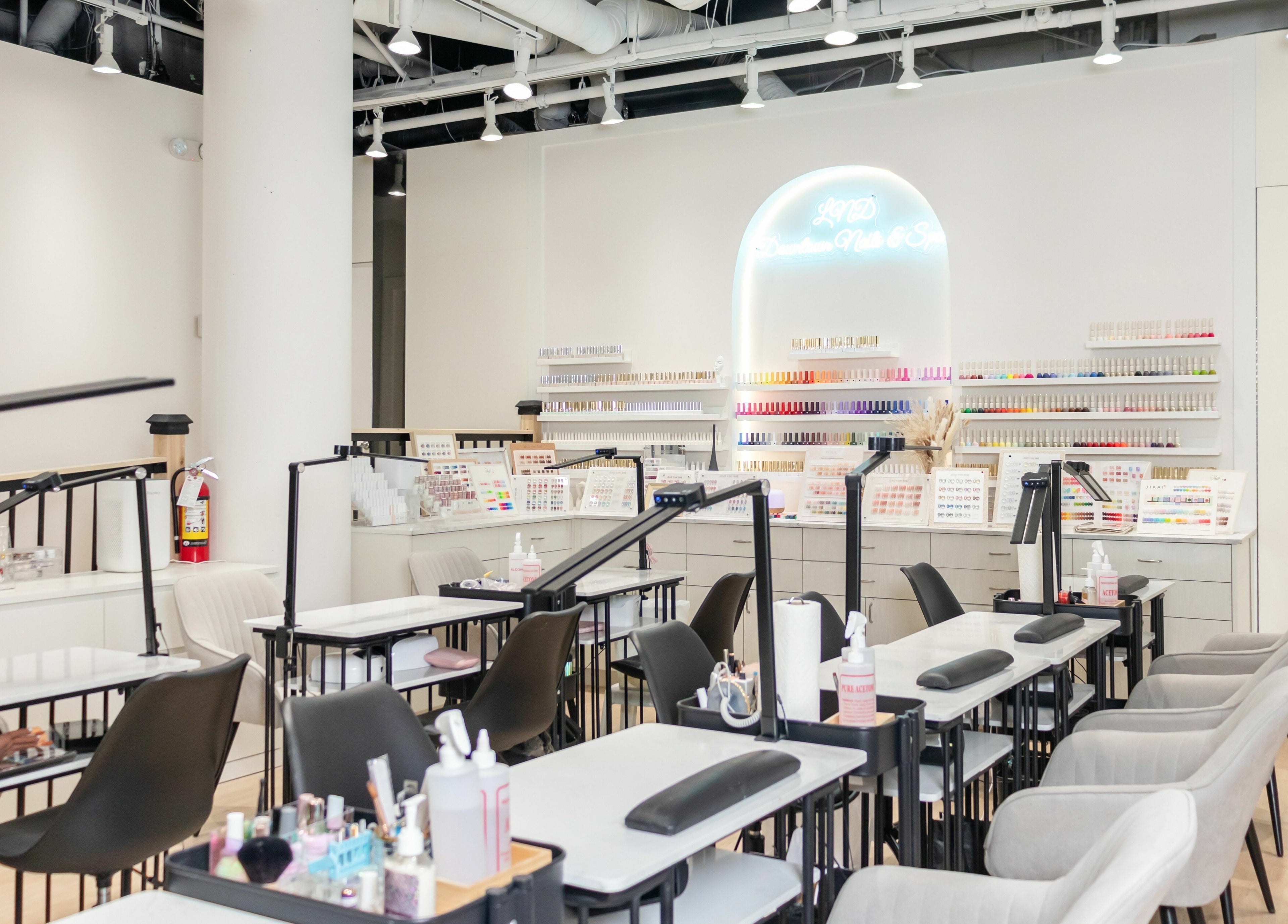 Modern interior of LND Downtown Nails and Spa, Vancouver, British Columbia, CA, showcasing nail stations and polish displays.