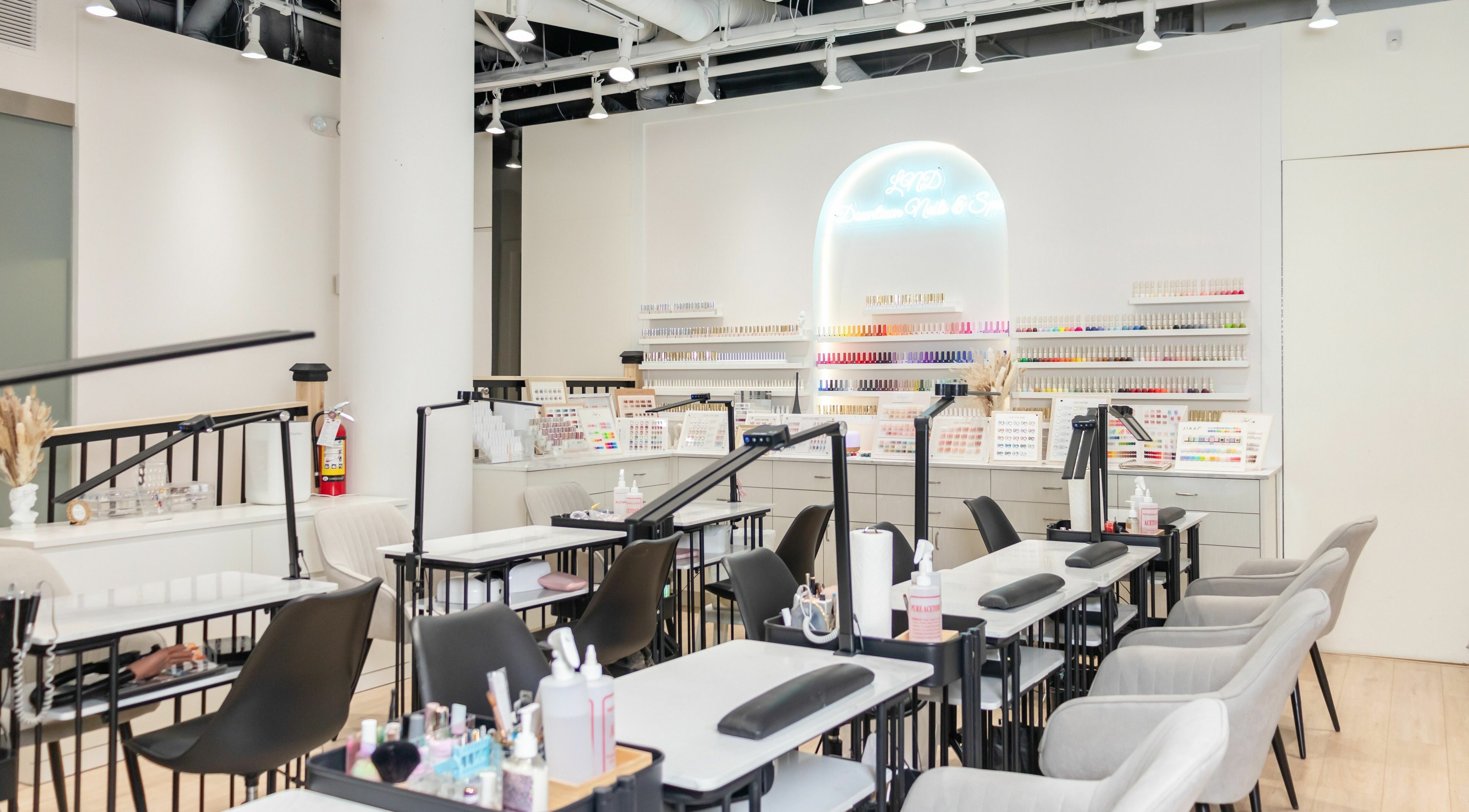 Modern interior of LND Downtown Nails and Spa, Vancouver, British Columbia, CA, showcasing nail stations and polish displays.
