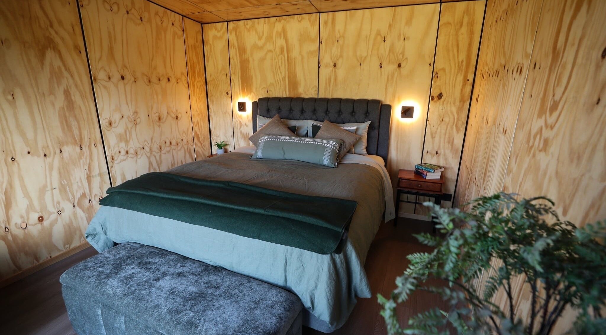 Cozy bedroom at Naked Soul Space, Rosewill, Canterbury, NZ with wooden walls and soft lighting.