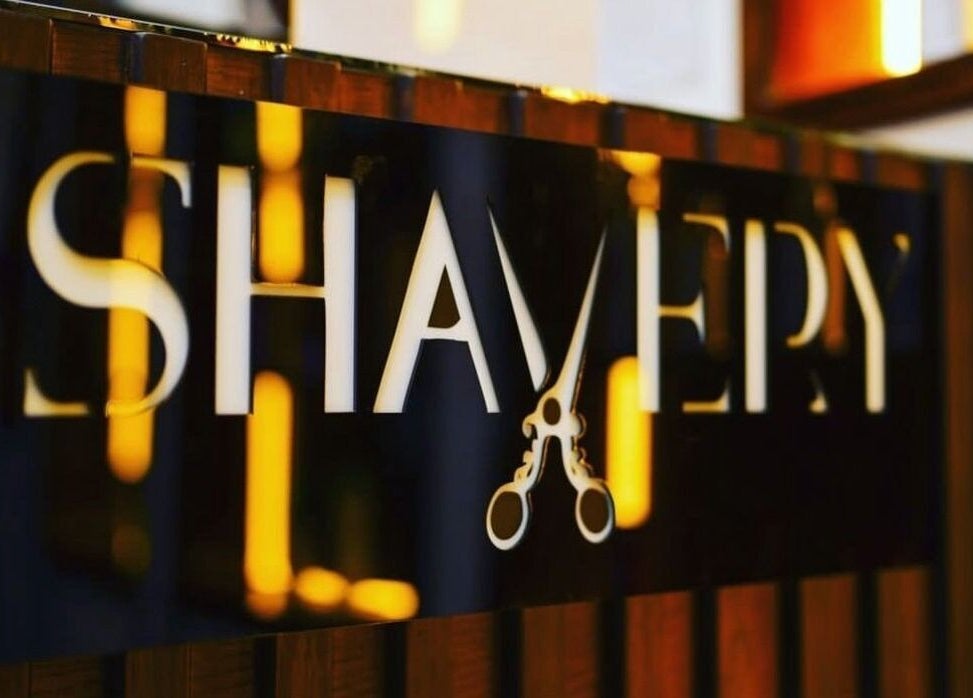 Stylish signage of Shavery Salon I شيفري للحلاقة at Al Khobar, Eastern Province, SA, with a scissors design.