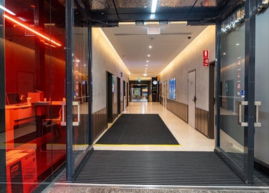 Modern entrance of Monlash in Brisbane City, Queensland, AU with sleek glass doors and ambient lighting.