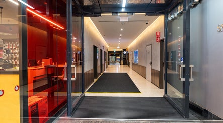 Modern entrance of Monlash in Brisbane City, Queensland, AU with sleek glass doors and ambient lighting.