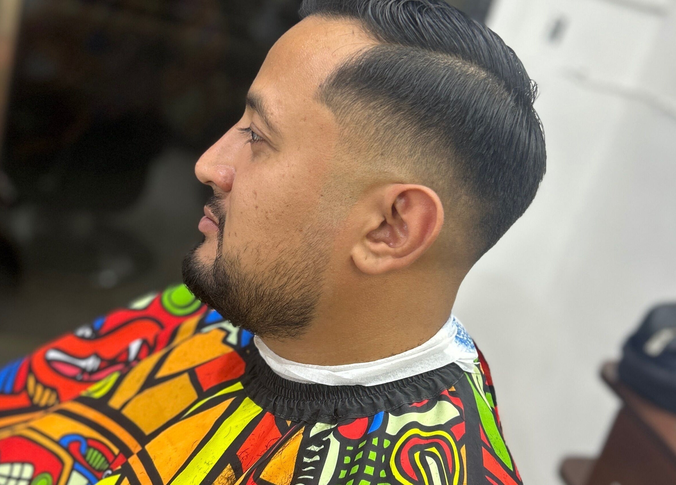 Cliente en Chris Barber, San Francisco De Campeche, Campeche, MX, con un peinado moderno y capa colorida.