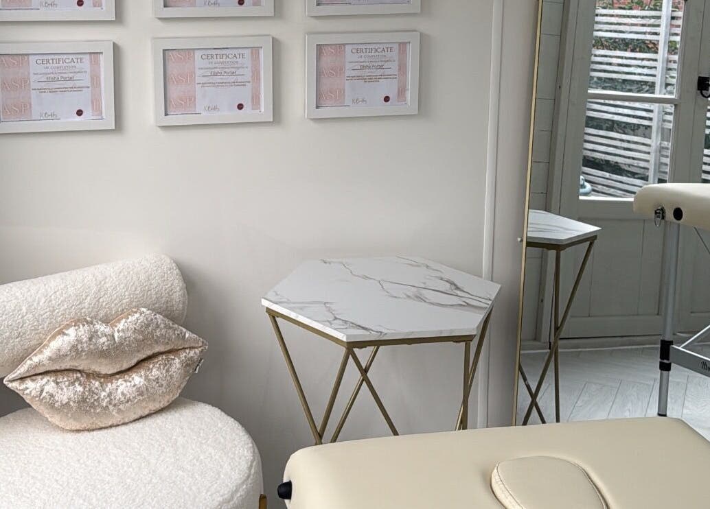Chic interior at Aesthetics By Lish, Worcester, England, featuring a stylish chair and certificates.