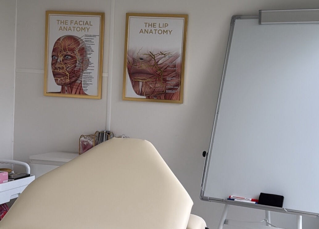 Aesthetics By Lish in Worcester, England. Room features anatomical posters and a whiteboard for learning.