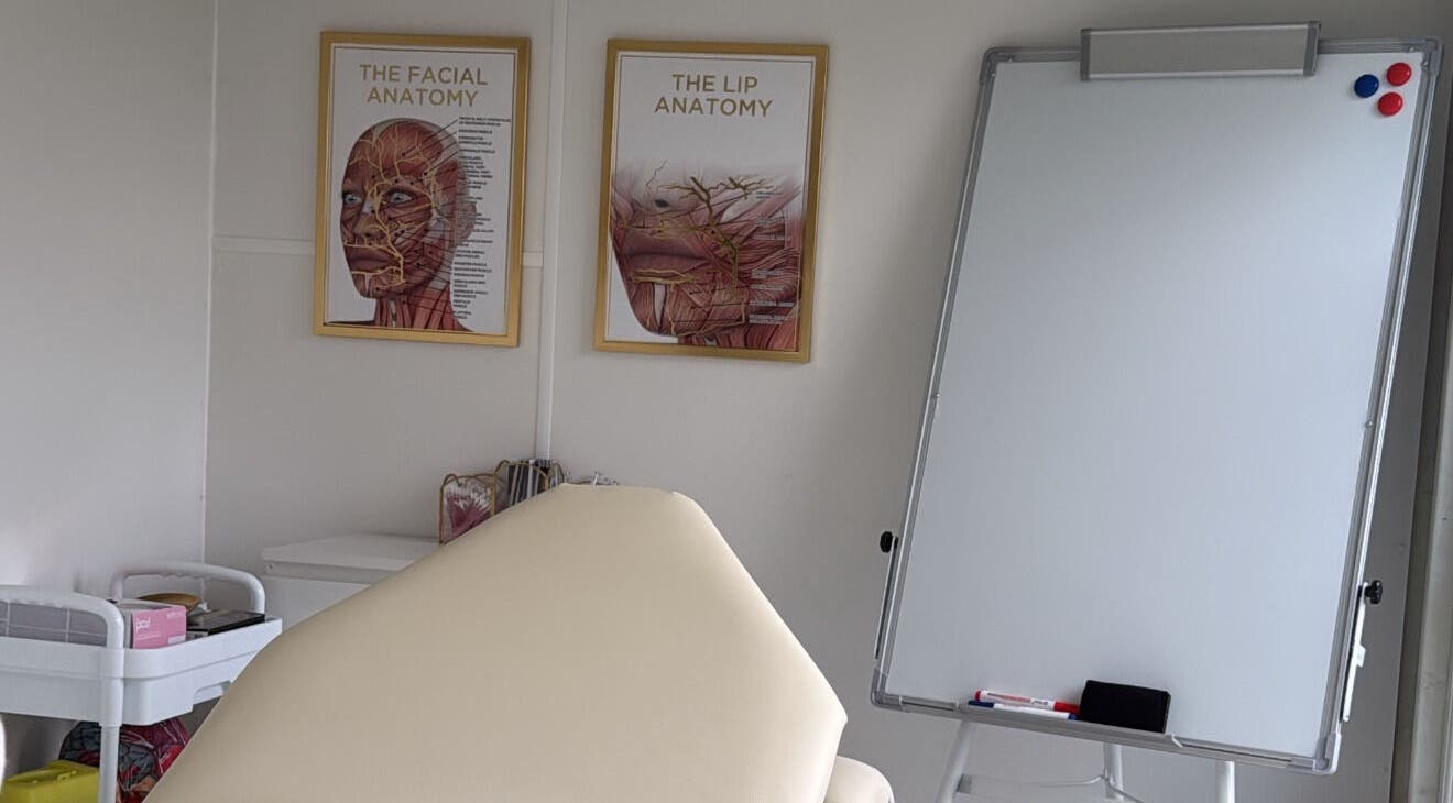 Aesthetics By Lish in Worcester, England. Room features anatomical posters and a whiteboard for learning.