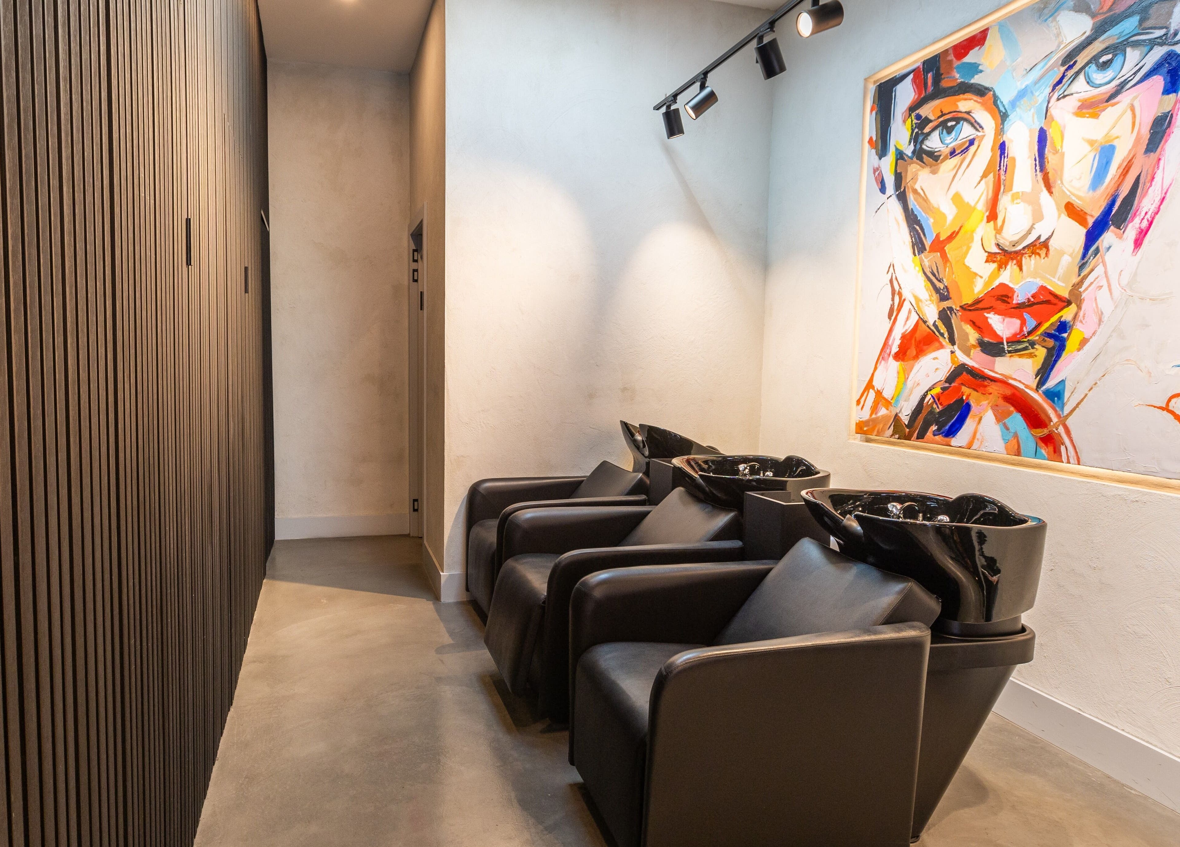 Chic salon washing station at Eran Benn, Melbourne, Victoria, AU with modern art on the wall.