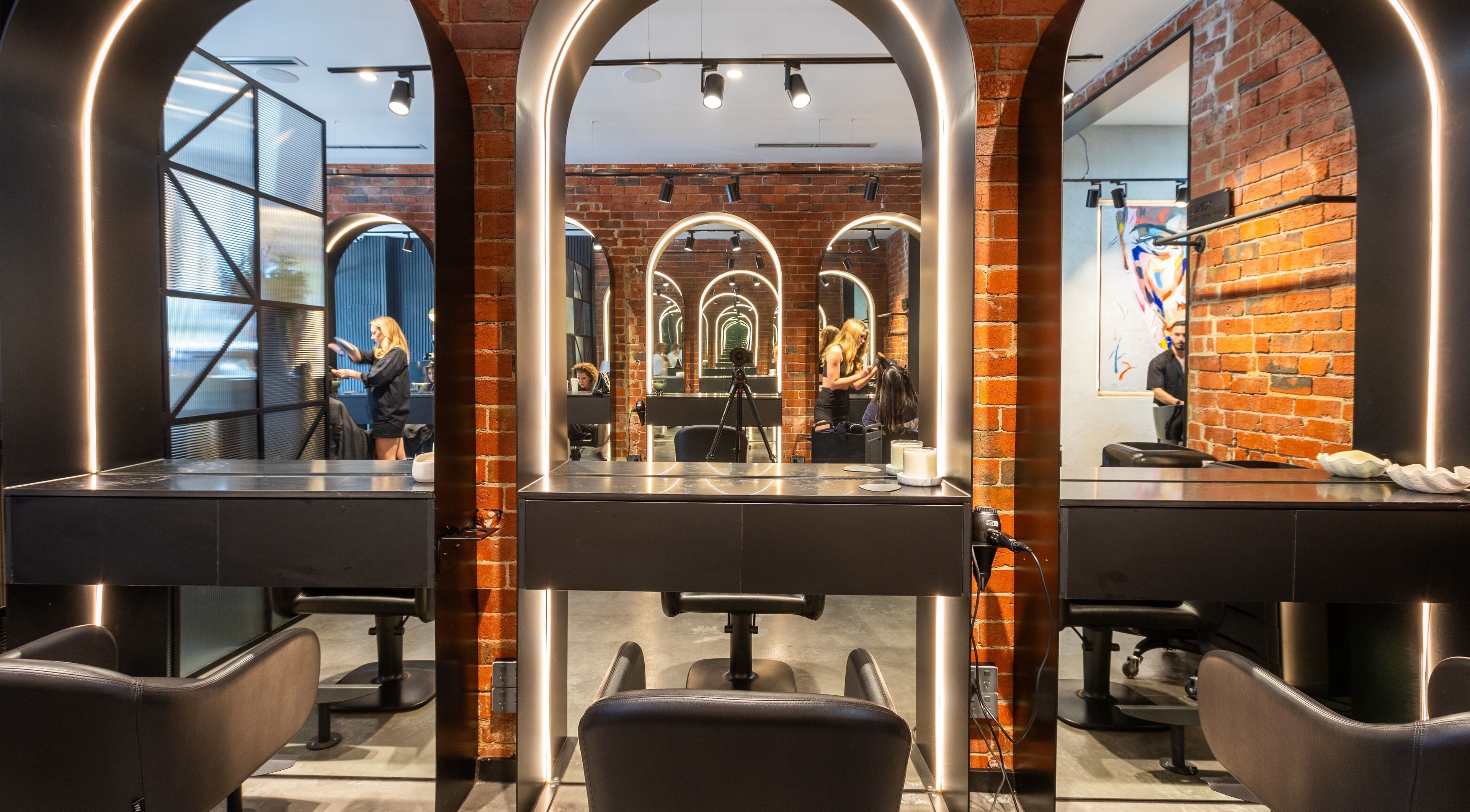 Eran Benn salon interior with modern mirrors and brick walls, Melbourne, Victoria, AU.