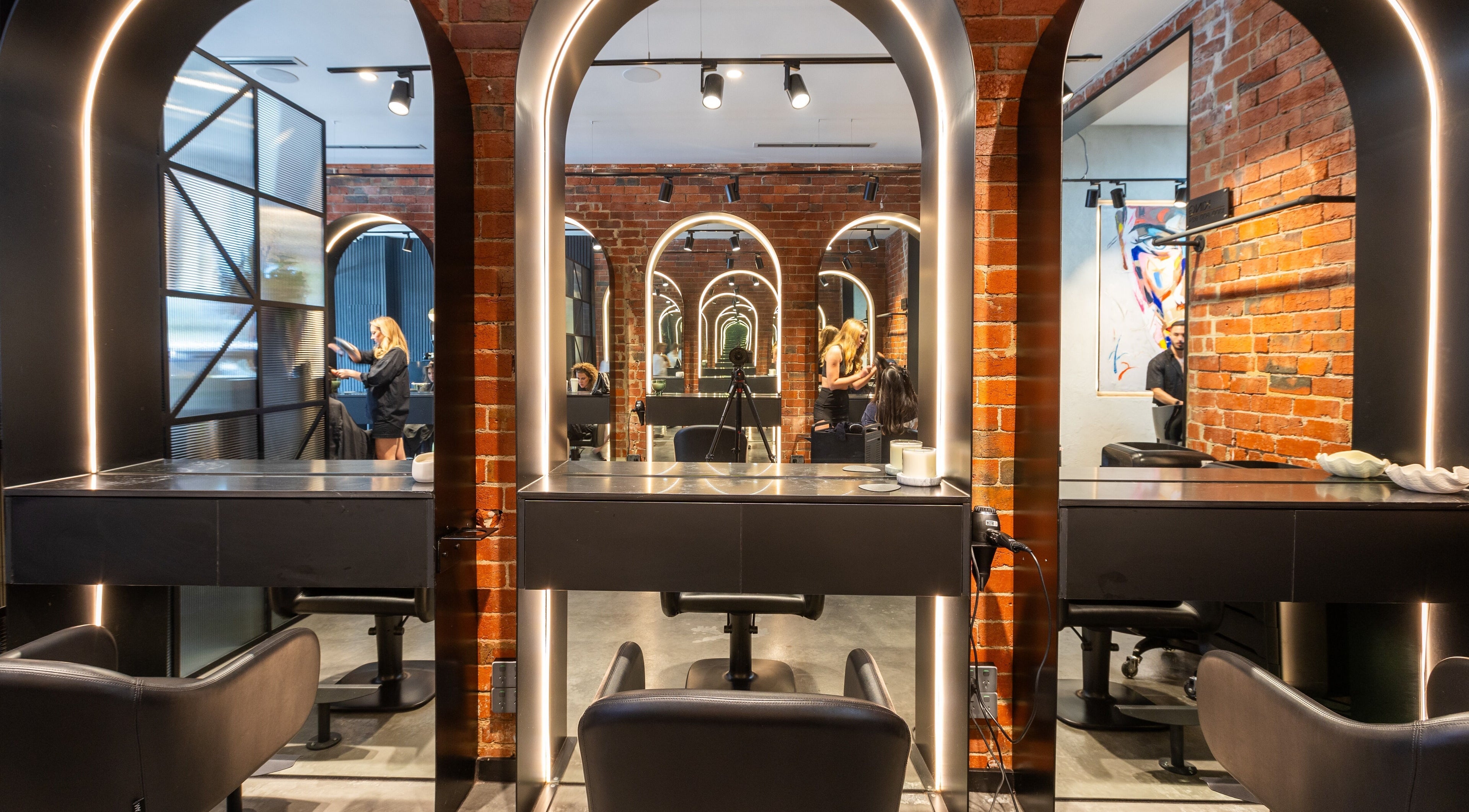 Eran Benn salon interior with modern mirrors and brick walls, Melbourne, Victoria, AU.