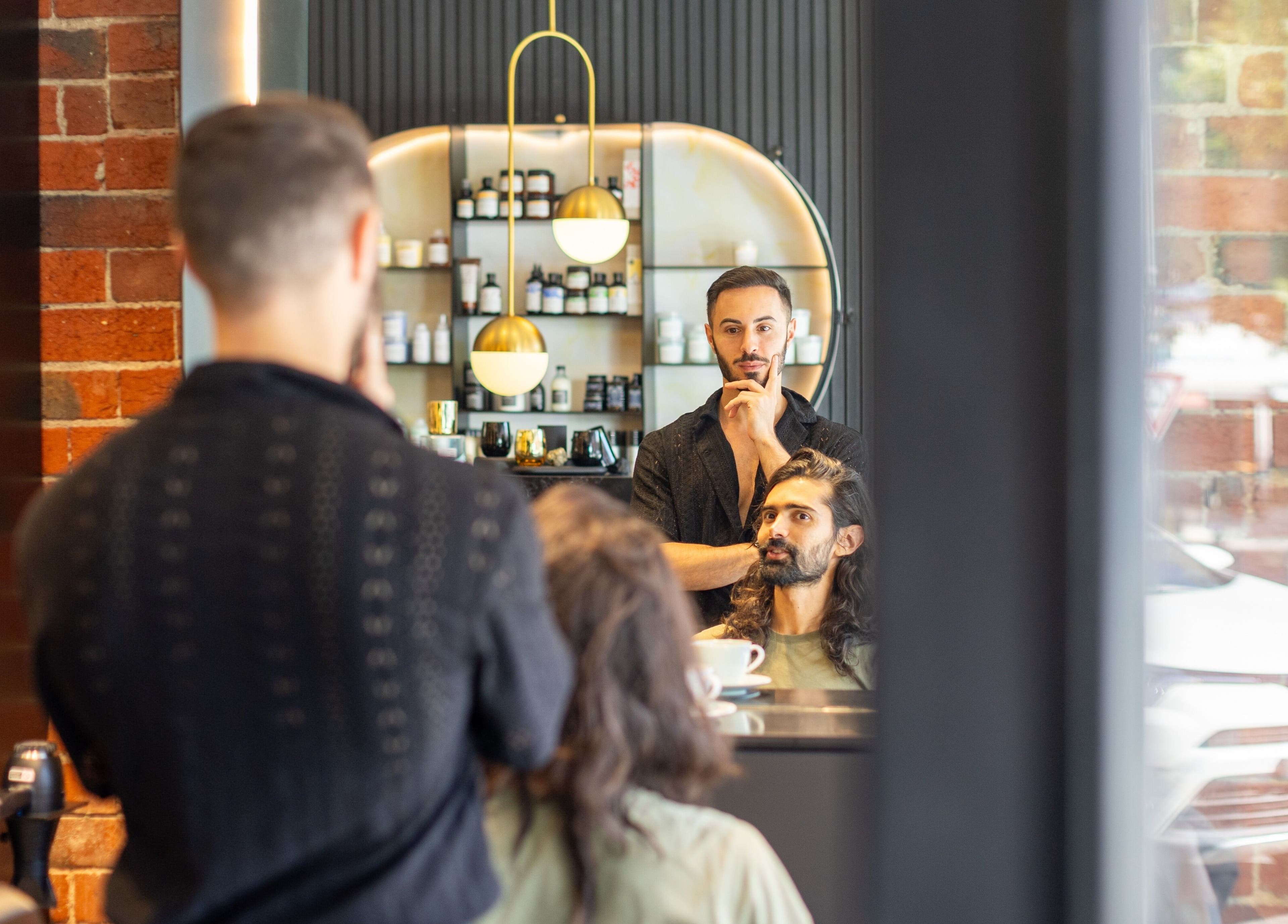 Eran Benn salon in Melbourne, Victoria, AU, showcasing a stylist with a client in a modern, chic ambiance.