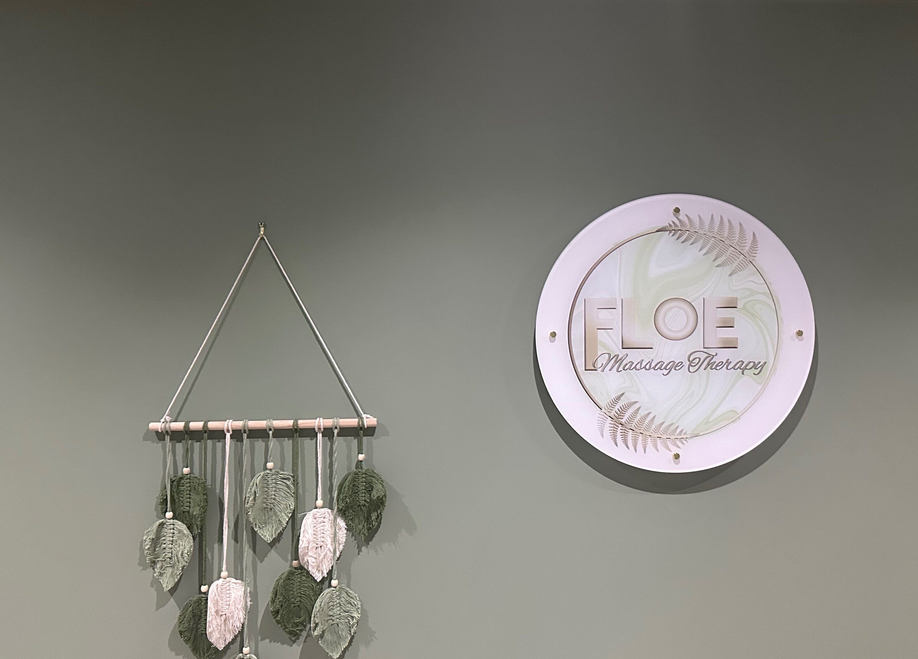 FLoE Massage Therapy signage on a calming sage wall at Sutton, England, GB with decorative hanging.