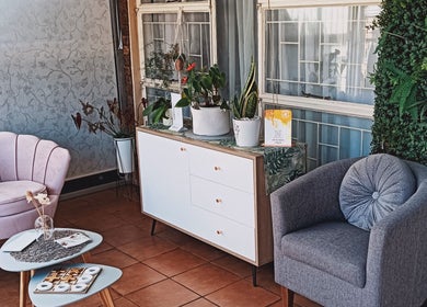 Elegant waiting area at Lumé Beauté, Centurion, Gauteng, ZA with plush seating and lush greenery.