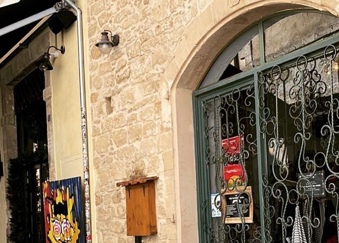 Charming stone facade of The Old Barber House in Paphos, CY, showcasing intricate ironwork details.