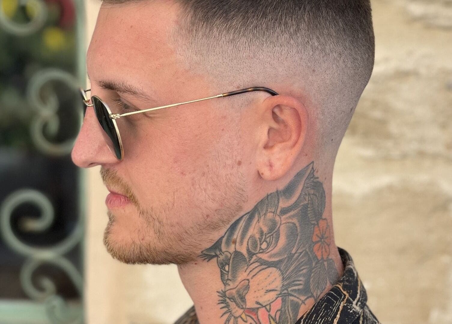 Close-up of a man with sunglasses and neck tattoo at The Old Barber House, Paphos, Paphos, CY.