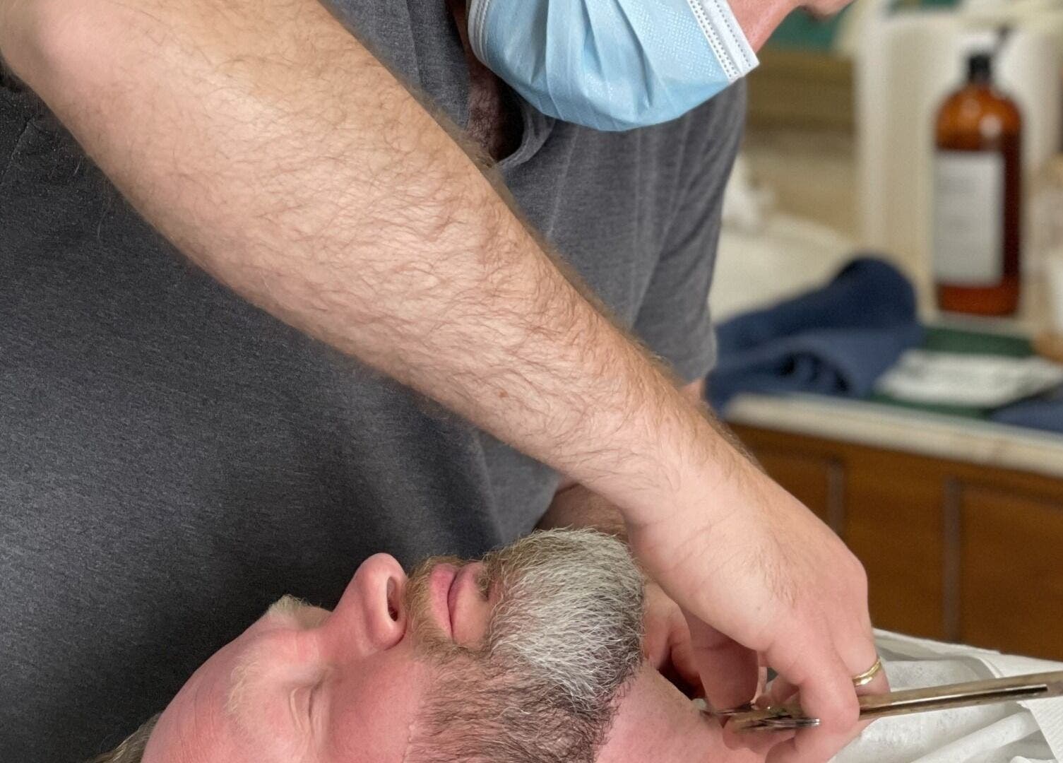 A barber trims a client's beard at The Old Barber House, Paphos, Paphos, CY.