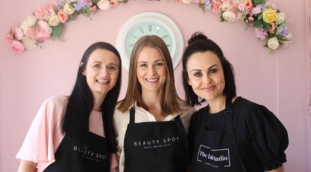 Three smiling beauticians at Beauty Spot Salon, Port Elizabeth, Eastern Cape, ZA, with floral decor.