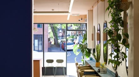 Interior of Hair by Joshuaa Shaun, Birmingham, showcasing stylish chairs, mirrors, and lush plants.