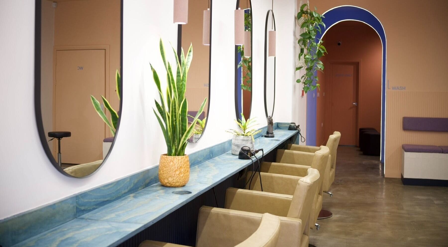 Modern salon interior at Hair by Joshuaa Shaun, Birmingham, England, GB with elegant mirrors and plants.