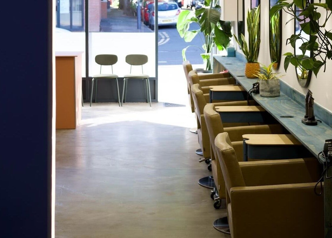 Elegant salon interior at Hair by Joshuaa Shaun, Birmingham, England, GB with modern chairs and plants.