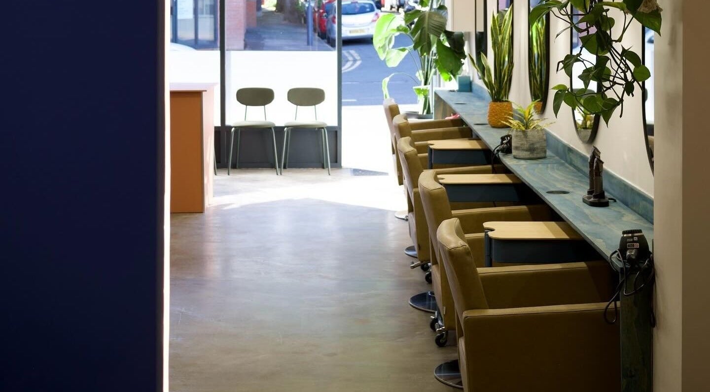 Elegant salon interior at Hair by Joshuaa Shaun, Birmingham, England, GB with modern chairs and plants.