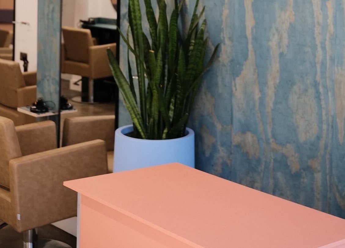 Modern salon interior at Hair by Joshuaa Shaun, Birmingham, England. Stylish chairs and green plant enhance the ambiance.