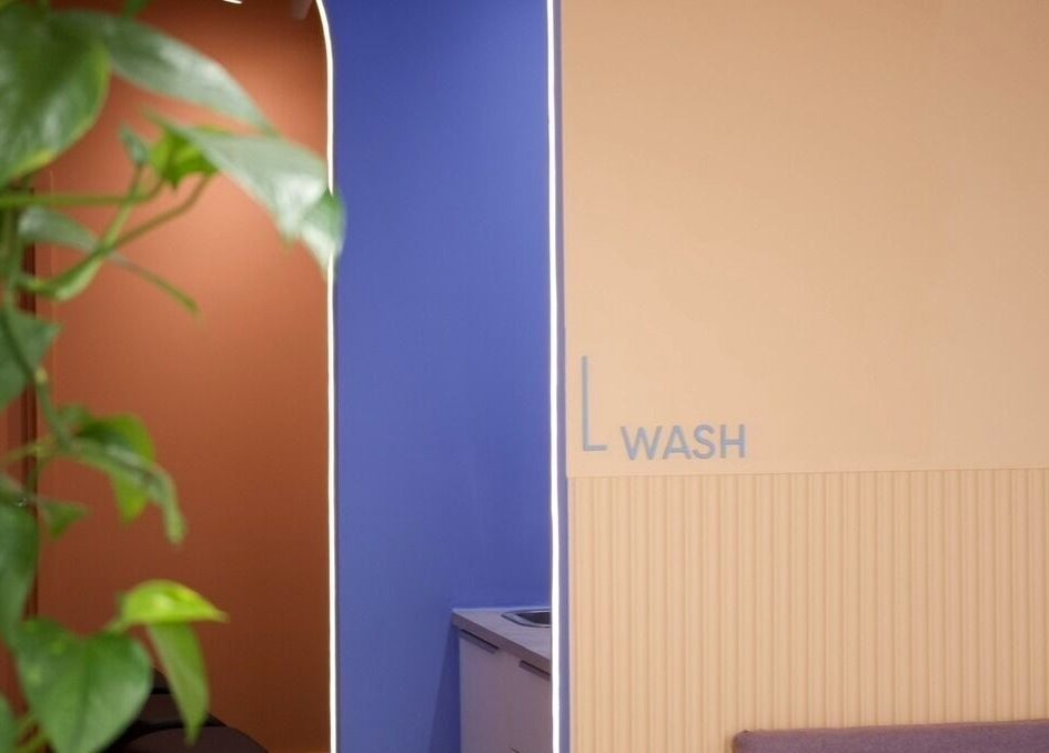 Vibrant wash area inside Hair by Joshuaa Shaun, Birmingham, England, GB, with green plant decor.