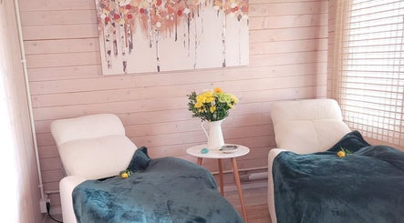 Relaxing lounge area at Holistic Healing & Wellbeing, Peterborough, England with cozy chairs and floral decor.