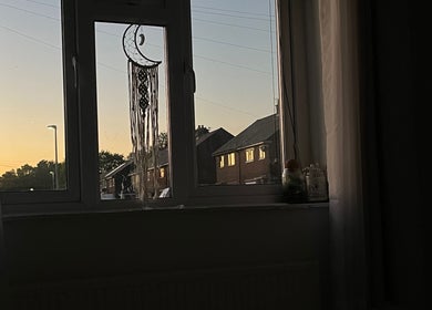 Tranquil sunset through window with dreamcatcher at beautified by ella, Preston, England, GB.