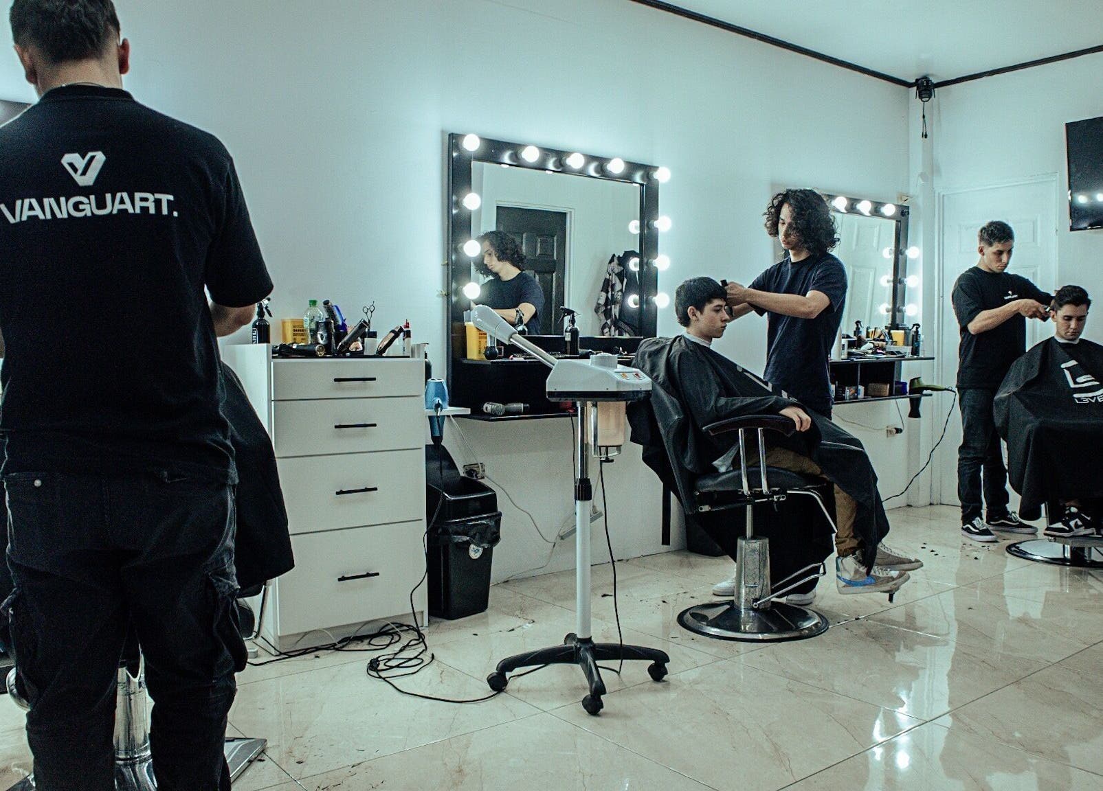 Salón moderno en Vanguart, Provincia De Alajuela, CR con estilistas y clientes disfrutando del servicio.