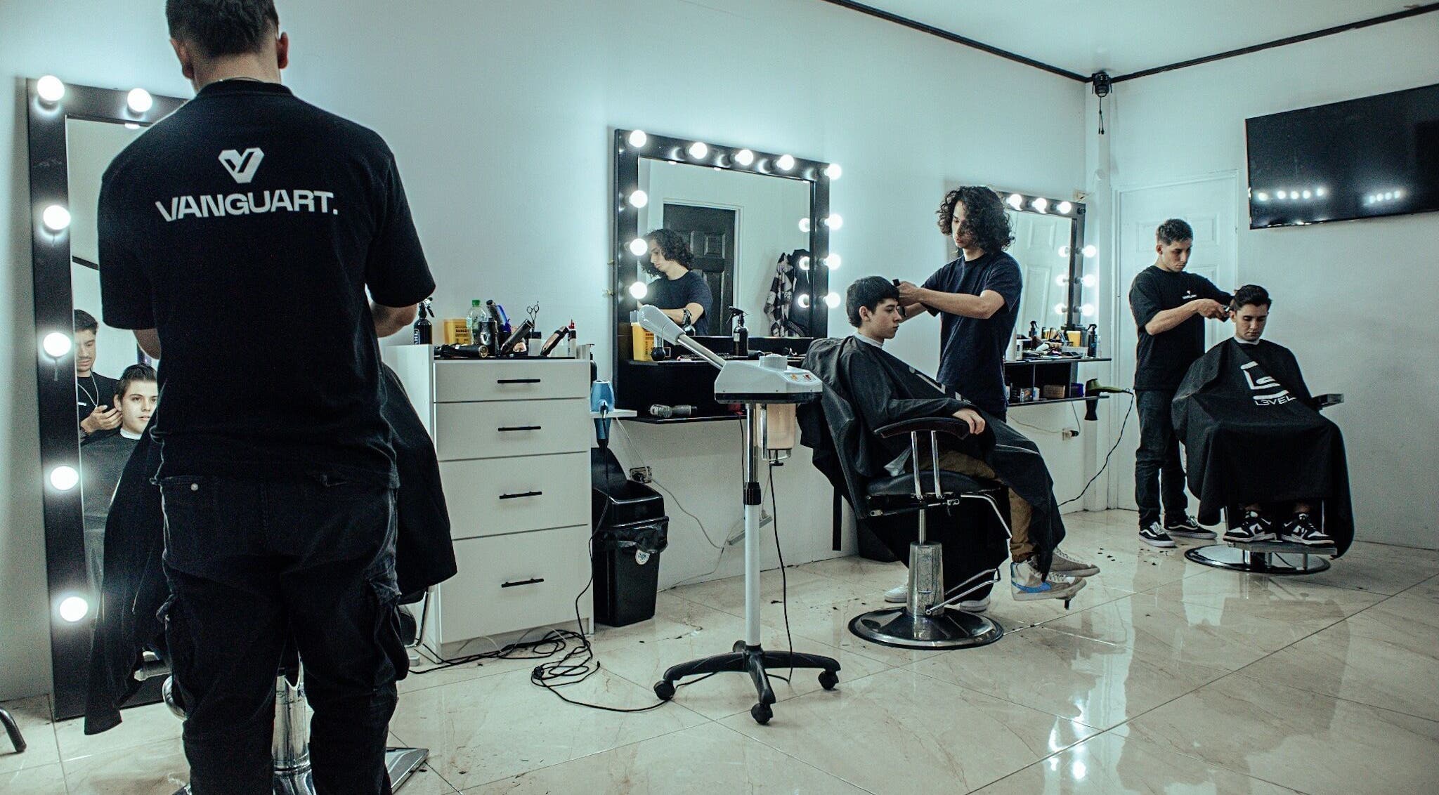 Salón moderno en Vanguart, Provincia De Alajuela, CR con estilistas y clientes disfrutando del servicio.