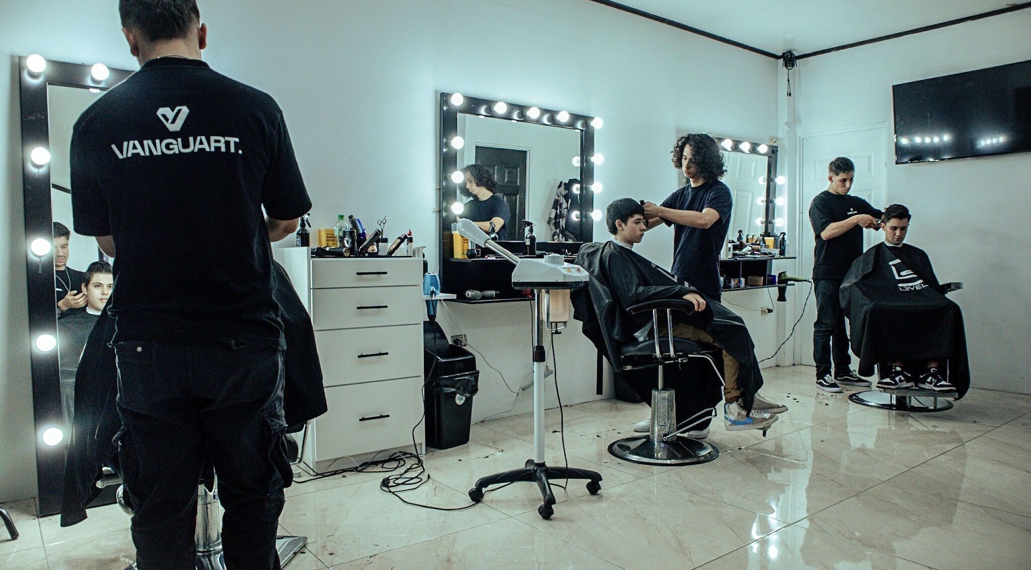 Salón moderno en Vanguart, Provincia De Alajuela, CR con estilistas y clientes disfrutando del servicio.