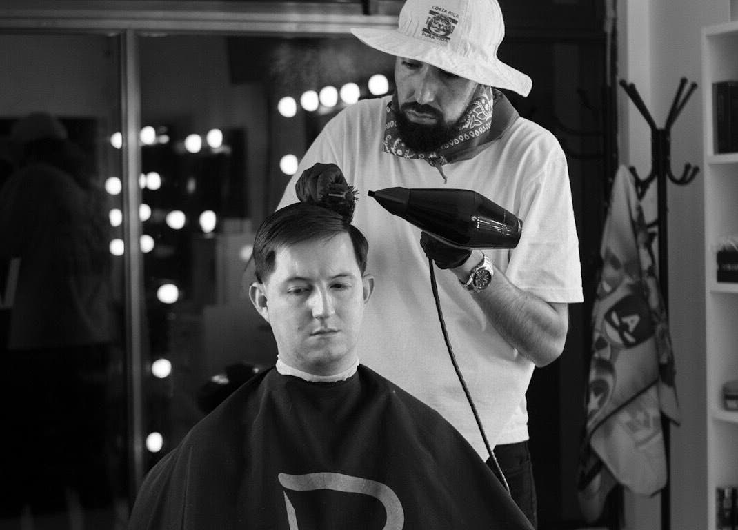 Estilista en Vanguart, Provincia De Alajuela, perfeccionando corte de cabello masculino.