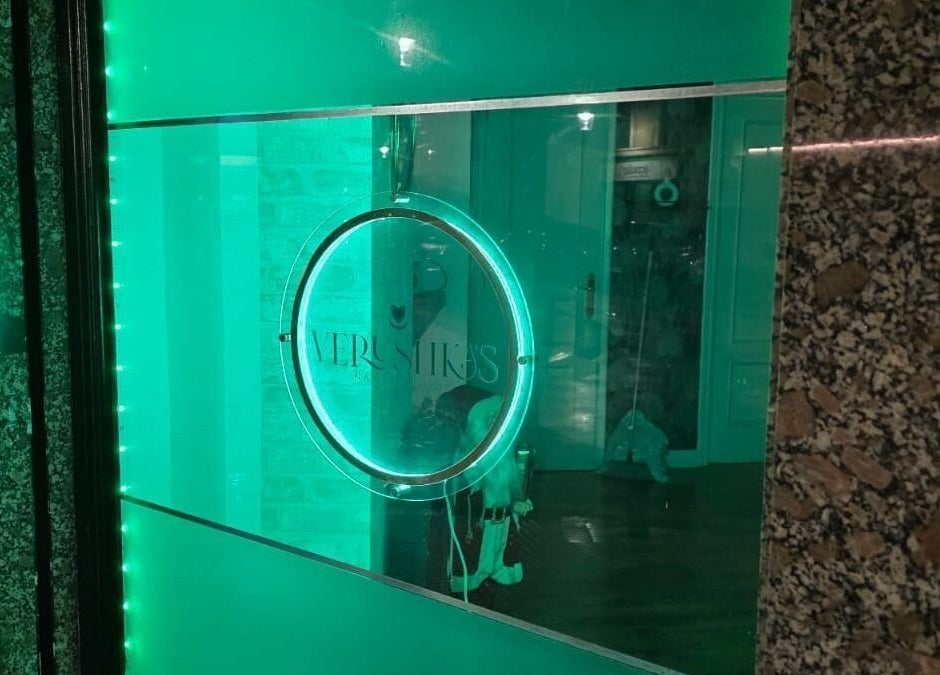 Fachada iluminada de Verushka's Nails Studio Gijon, destacando su distintivo color verde en Gijón, ES.