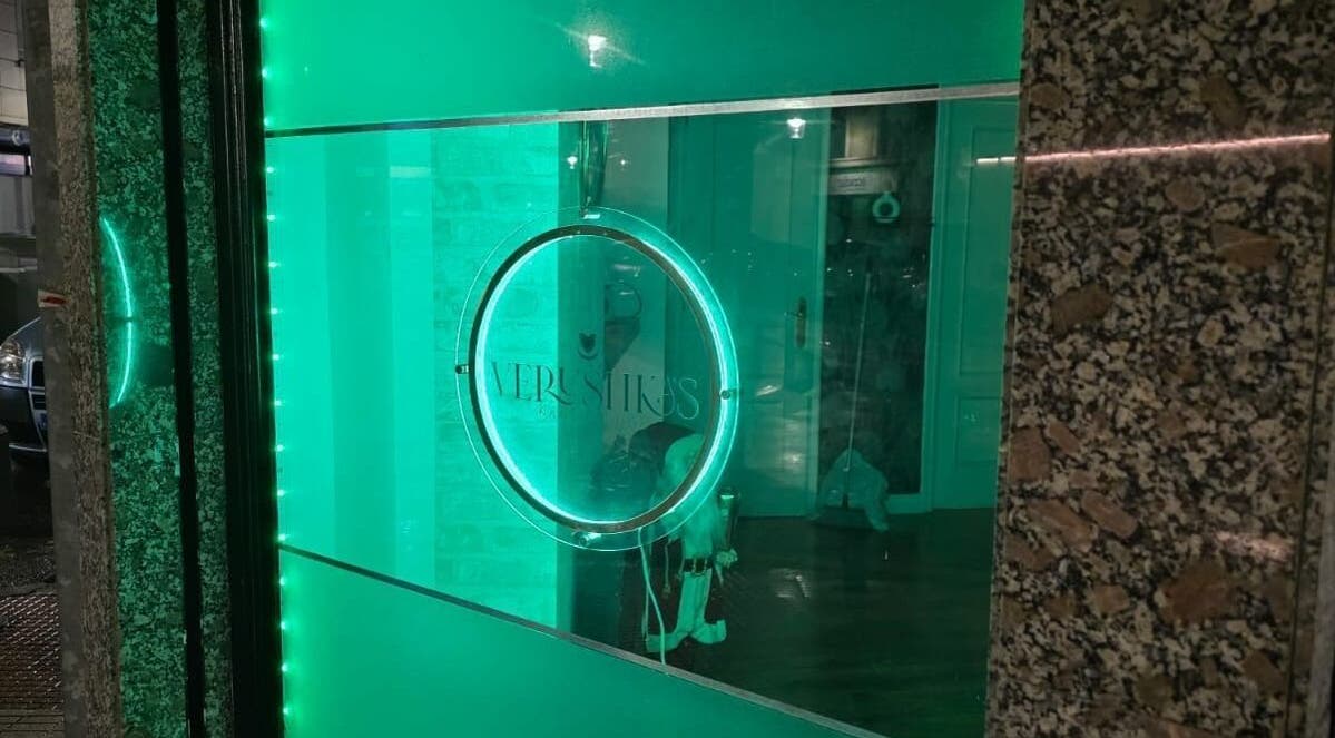 Fachada iluminada de Verushka's Nails Studio Gijon, destacando su distintivo color verde en Gijón, ES.