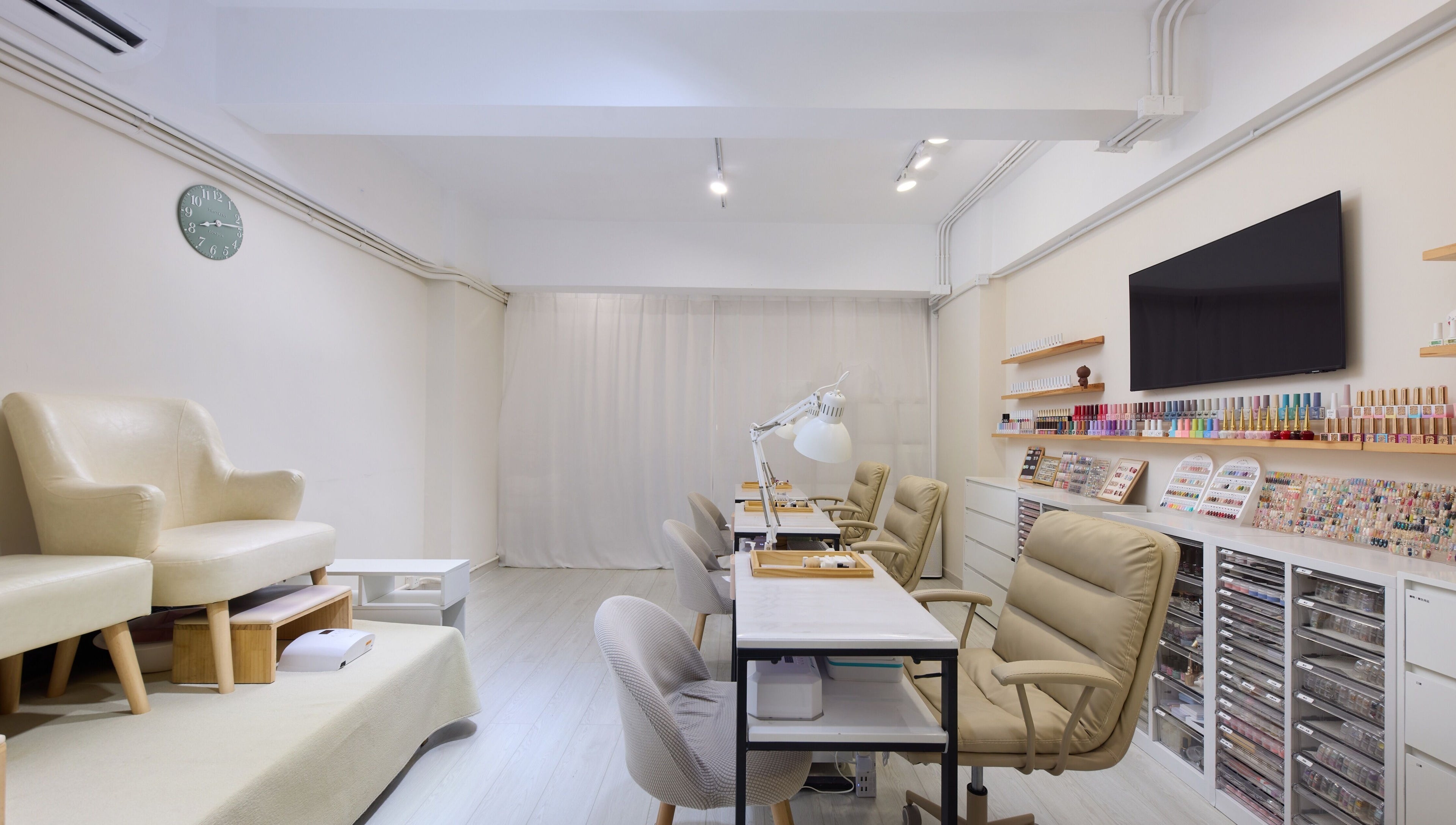 Sophisticated Nail Room in 香港島, HK with stylish seating and colorful nail polish display.