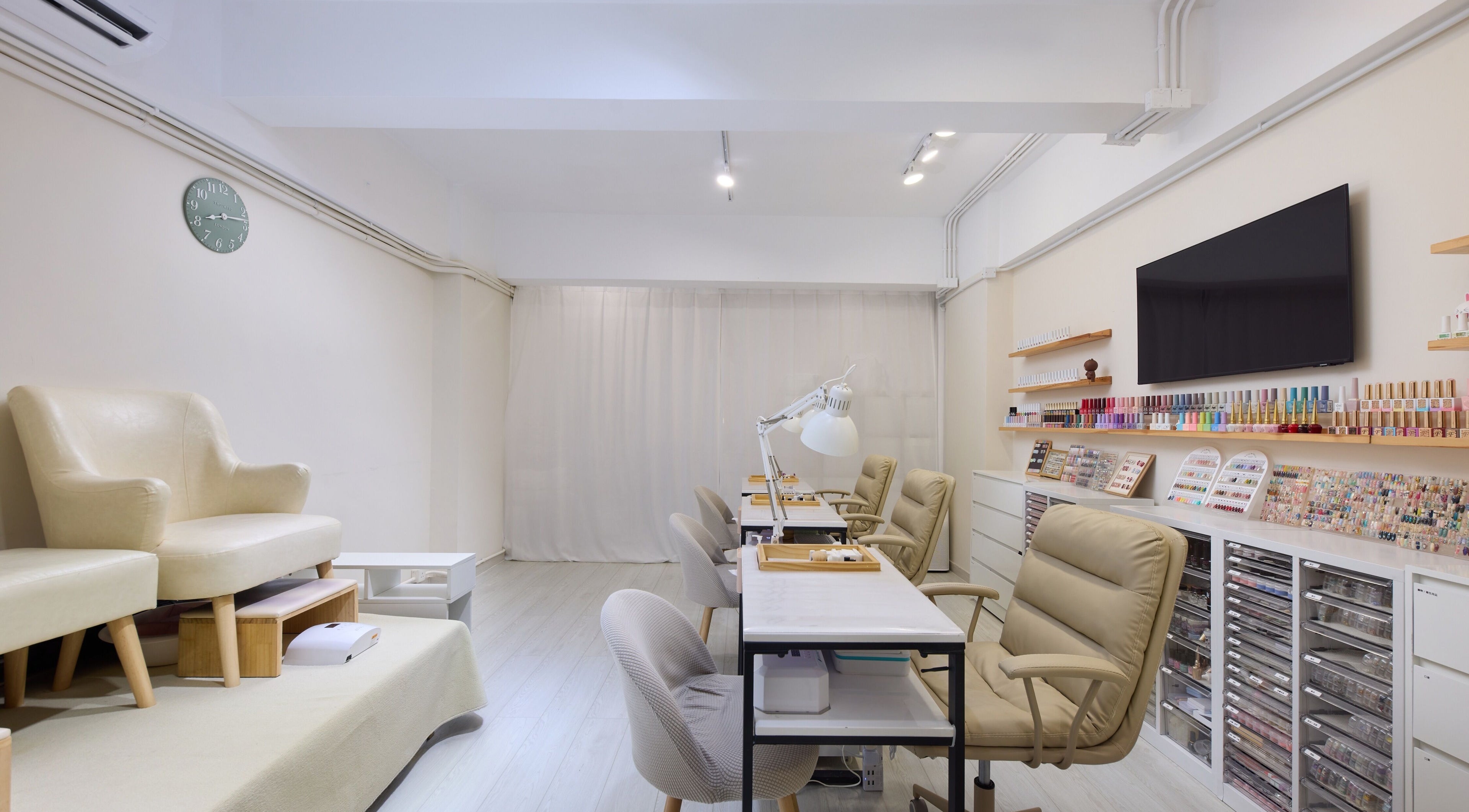 Sophisticated Nail Room in 香港島, HK with stylish seating and colorful nail polish display.