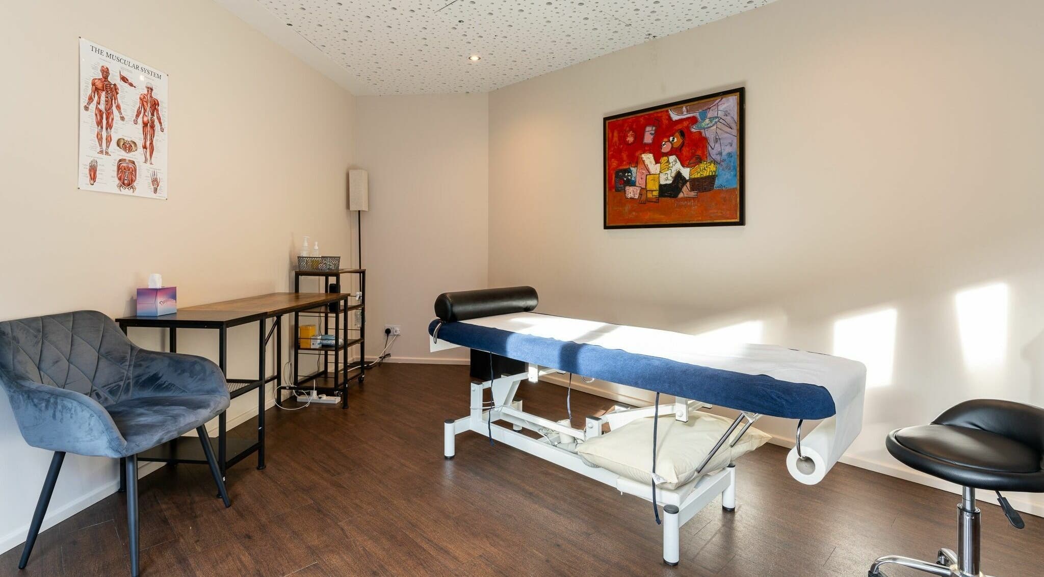 Tranquil treatment room at YK Wellness, London, England, GB with massage table and cozy seating.
