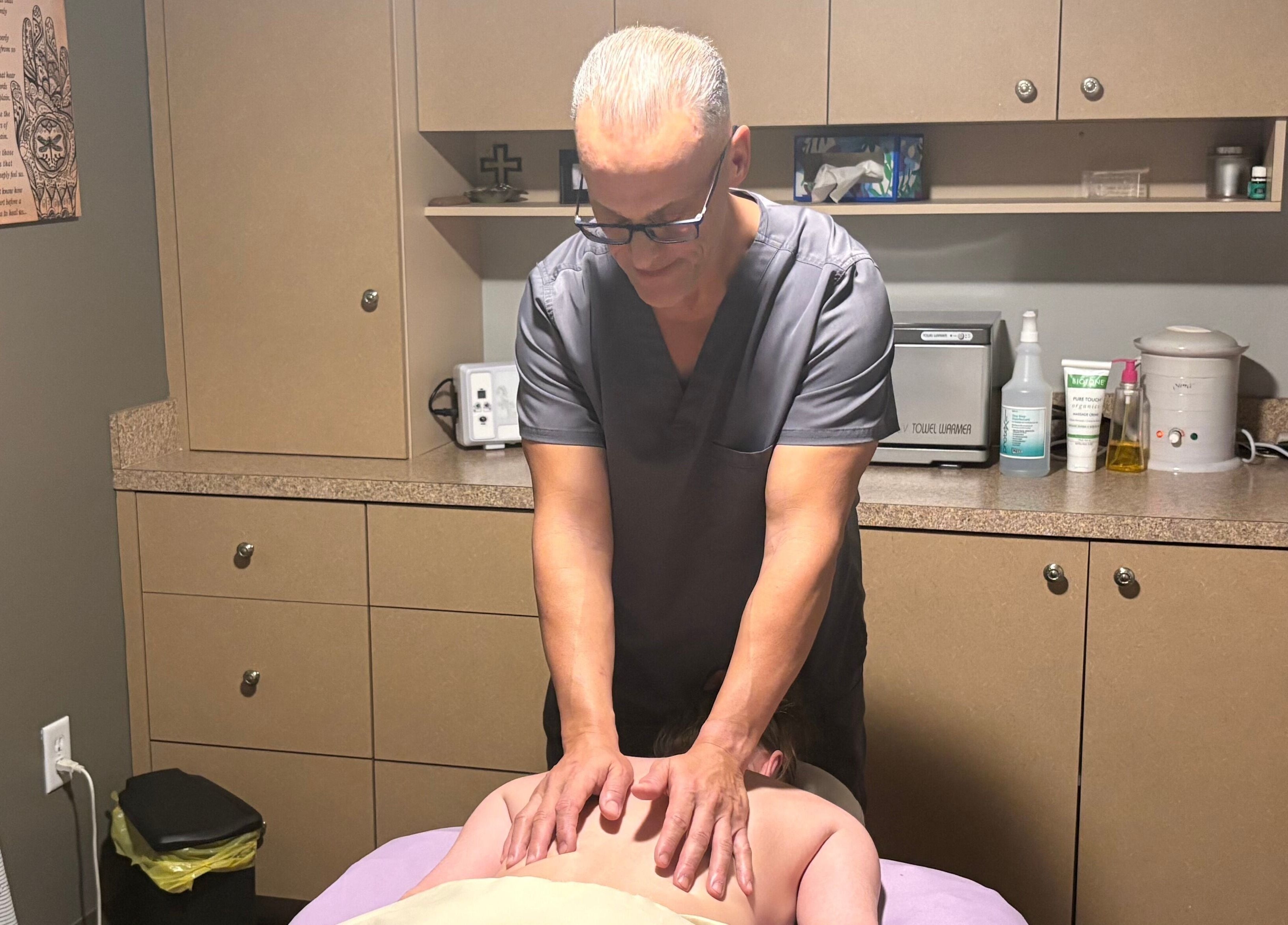Massage therapist at The Muscle Whisperer in New Port Richey, Florida, US giving a soothing back massage.