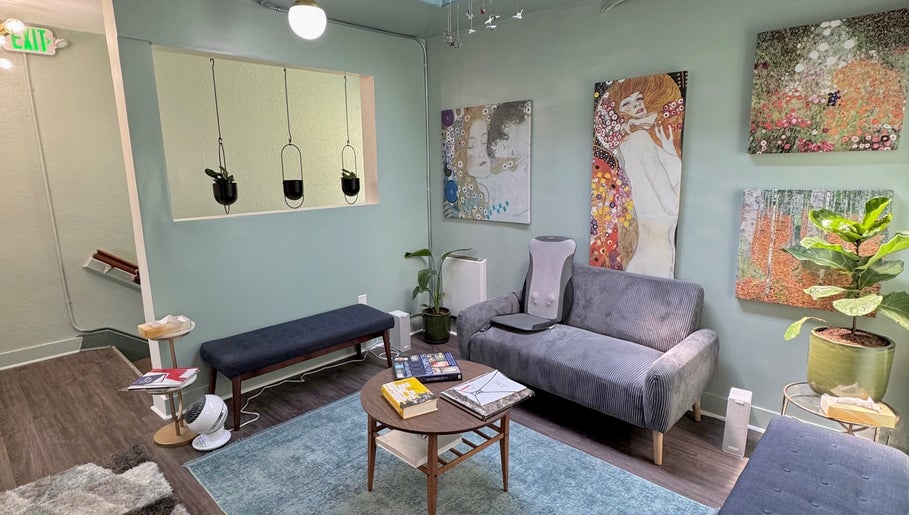 Chic waiting area at Reveal Electrolysis-Wallingford in Seattle, Washington, US with vibrant art and cozy seating.