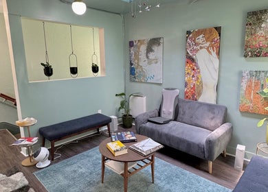 Chic waiting area at Reveal Electrolysis-Wallingford in Seattle, Washington, US with vibrant art and cozy seating.