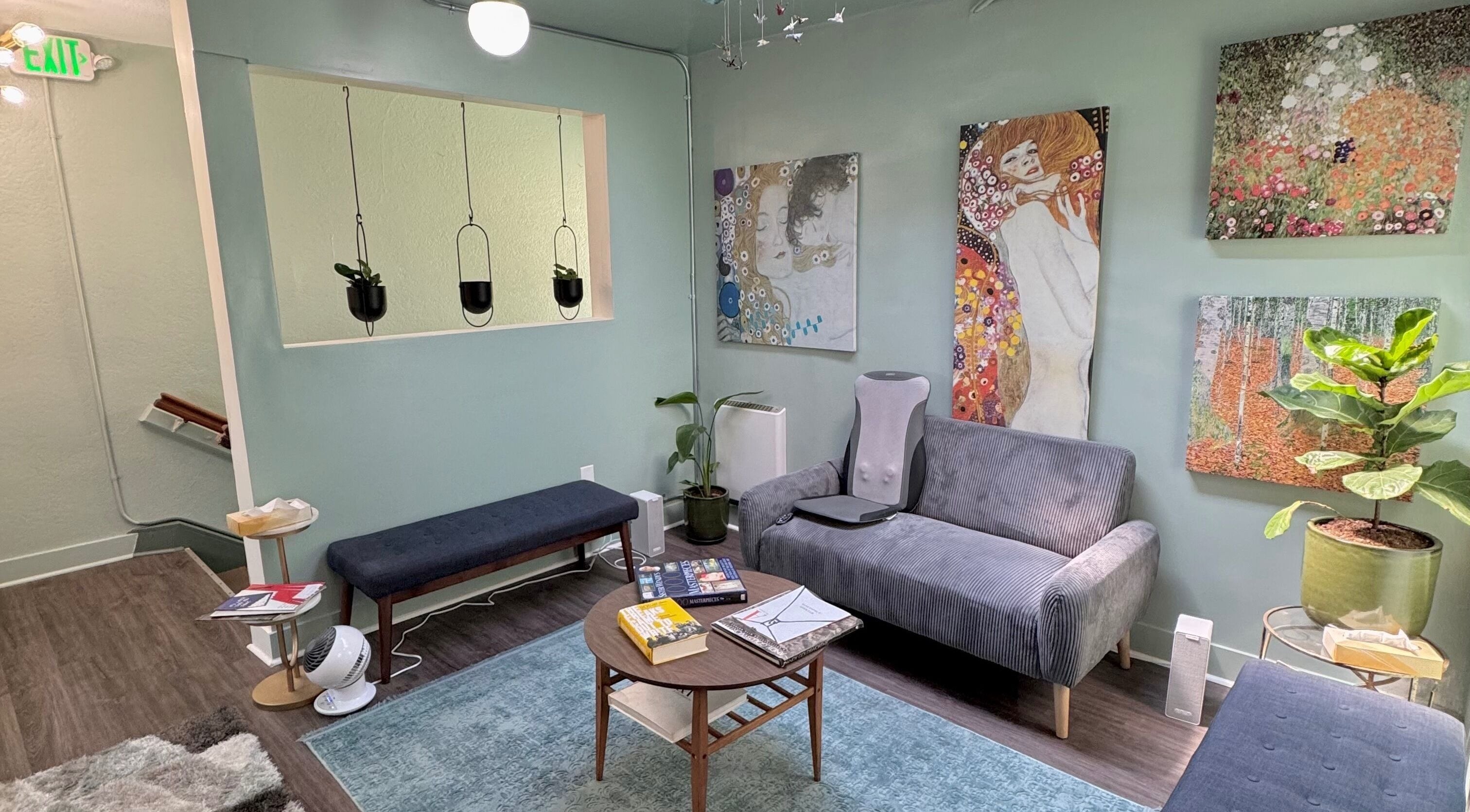 Chic waiting area at Reveal Electrolysis-Wallingford in Seattle, Washington, US with vibrant art and cozy seating.