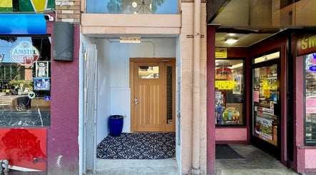 Entrance of Reveal Electrolysis-Wallingford at 11754, Seattle, Washington, US surrounded by vibrant shops.